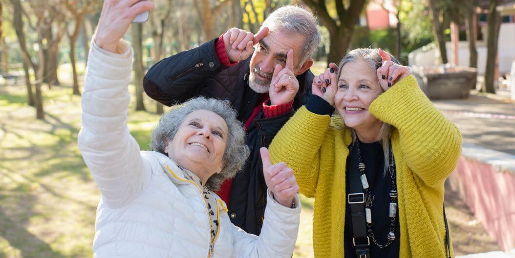 Seniors Walking in a Park in Graham Assisted Living Facility and Taking a Picture