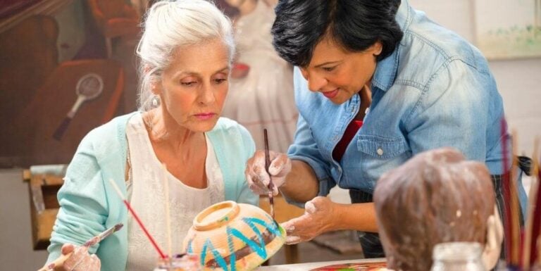 Elderly Woman Painting with Caregiver in Dementia Care Facility