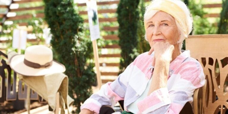 Elderly Woman Relaxing on Patio at Memory Care Facility