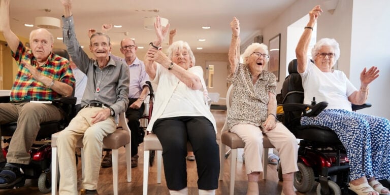 Group of Elderly Residents Doing Chair Exercises Together at an Assisted Living Facility